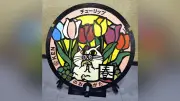 12歳の切り絵クリエイターKENさんがデザインしたネコとチューリップのマンホール蓋が福岡県直方市で完成