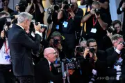 G・クルーニーさん、AFPカメラマンとトロフィー交換し撮影